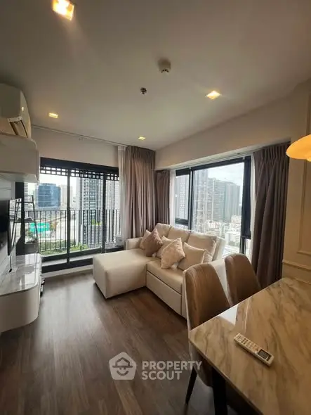 Modern living room with city view, stylish furniture, and natural light.