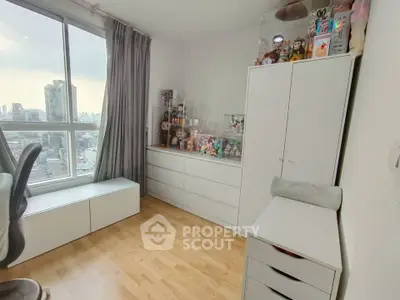 Bright and airy bedroom with city view, featuring modern white furniture and ample storage space.