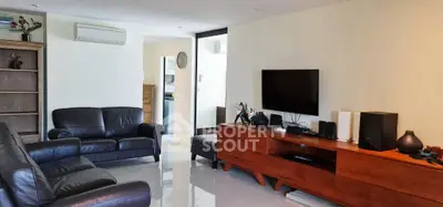 Spacious living room with modern leather sofas and sleek wooden TV console