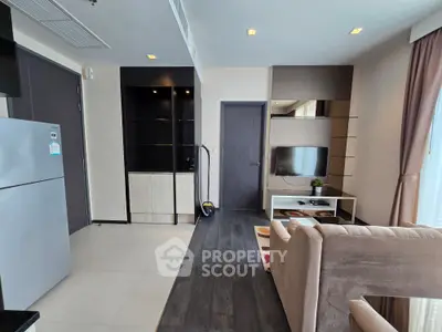 Modern living room with sleek design, featuring a cozy sofa, flat-screen TV, and stylish shelving units.