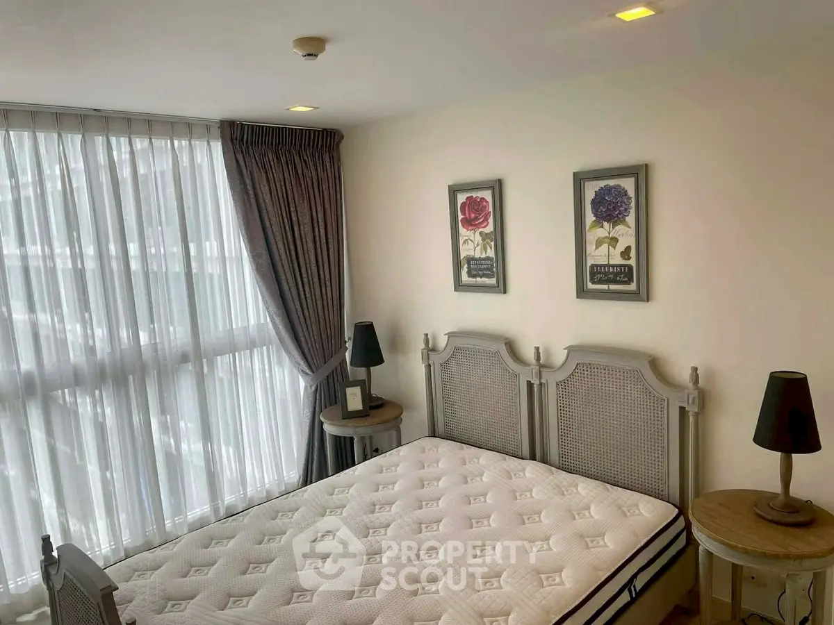 Cozy bedroom with elegant decor and large window for natural light