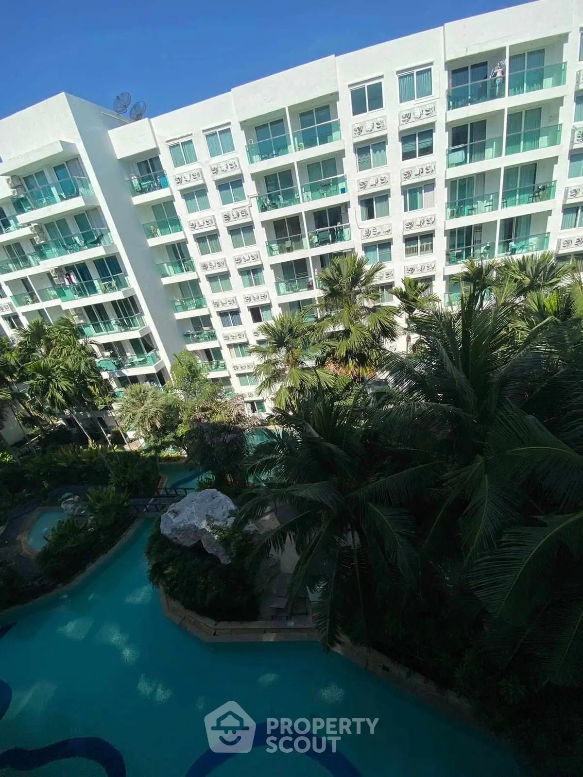 Luxurious condominium with pool view and lush greenery