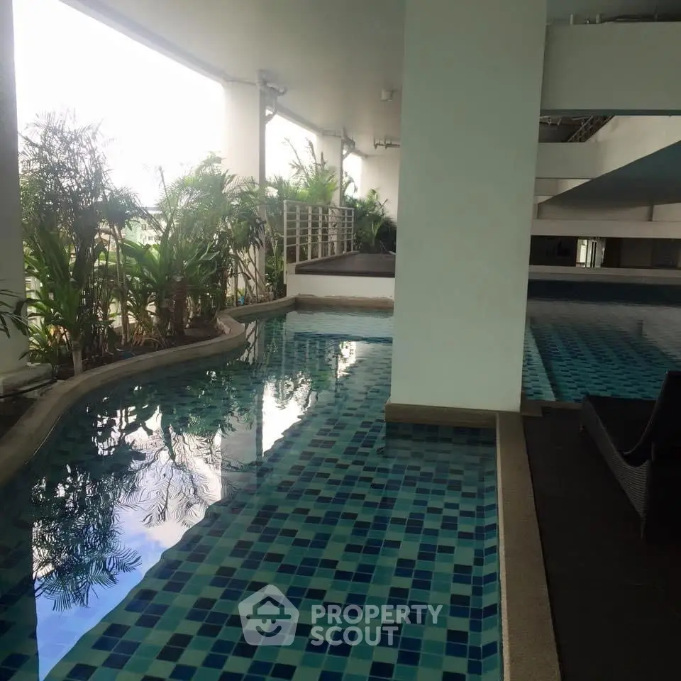 Luxurious indoor pool area with modern design and lush greenery