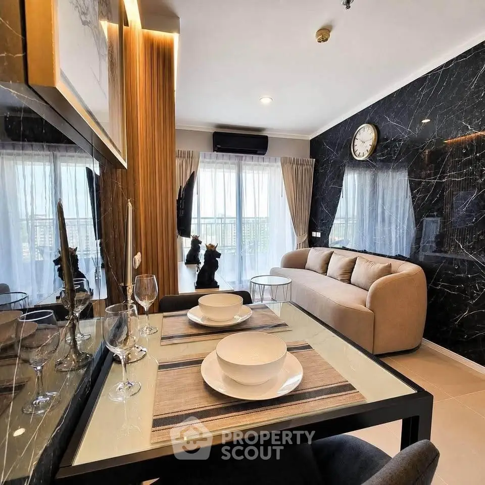 Modern living room with elegant decor, marble accent wall, and dining area in a stylish apartment.