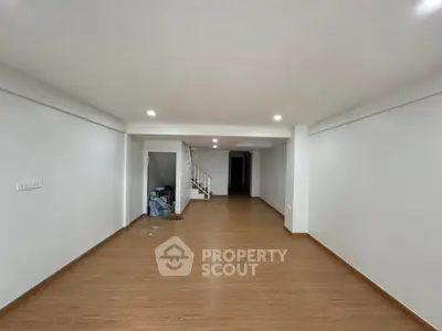 Spacious open-plan living area with wooden flooring and modern lighting, ideal for customization.