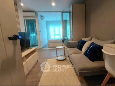 Modern living room with cozy sofa and stylish decor leading to a bright bedroom.
