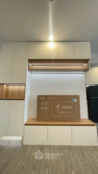 Modern living room with built-in cabinets and new 43-inch QLED TV setup.