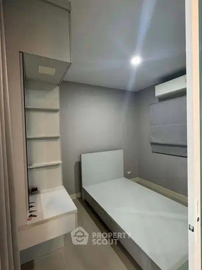 Modern minimalist bedroom with sleek design and built-in storage solutions.
