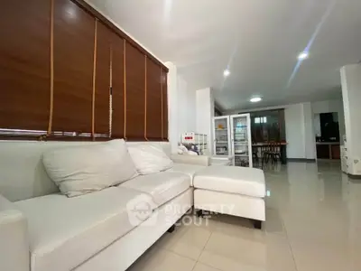 Spacious living room with modern white sofa and sleek tiled flooring