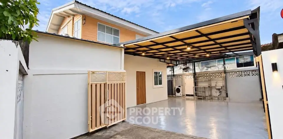 Modern two-story house with spacious covered parking area and sleek exterior design.