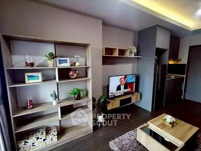 Modern living room with stylish shelving and wall-mounted TV in a cozy apartment.