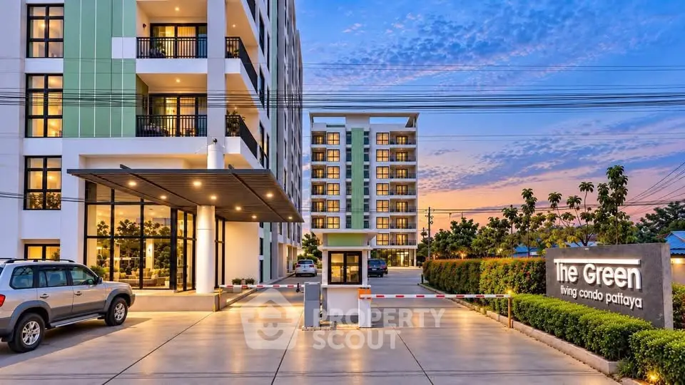 Modern condo building exterior with lush landscaping and sunset sky in Pattaya.