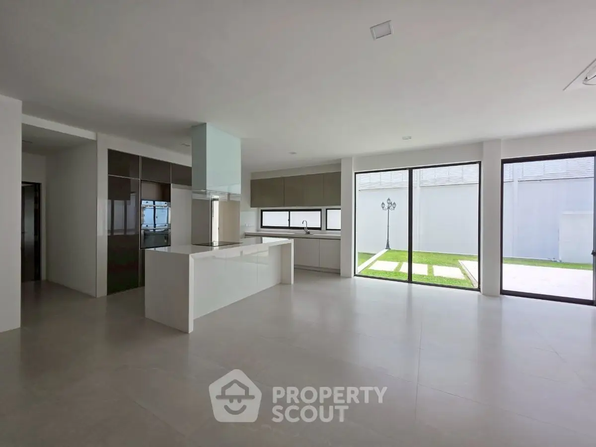 Spacious modern kitchen with open layout and large windows overlooking garden