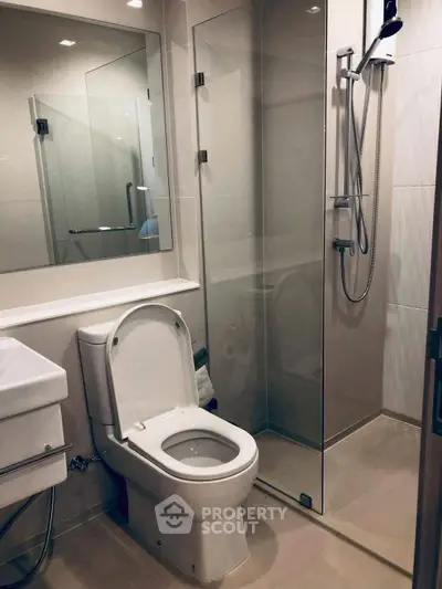 Modern bathroom with glass shower and sleek fixtures in a contemporary apartment.