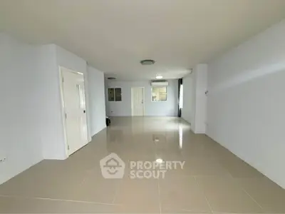 Spacious empty living room with glossy tiled floors and white walls, ready for customization.