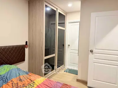 Cozy bedroom with modern wardrobe and colorful bedding in a stylish apartment.