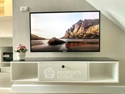 Modern living room with wall-mounted TV and sleek storage unit