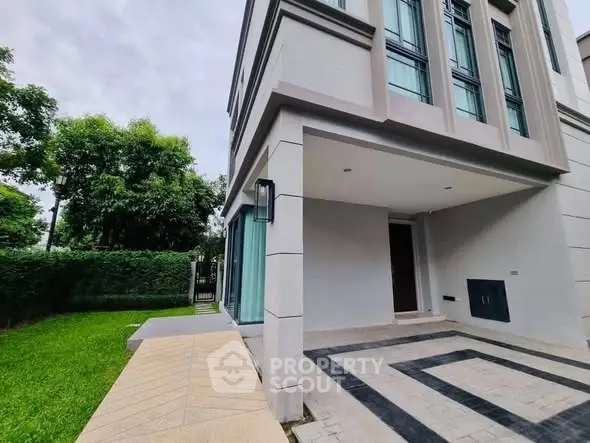 Modern building exterior with lush green garden and stylish entrance