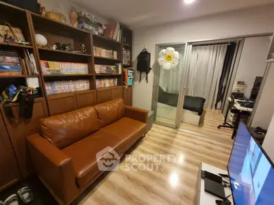 Cozy living room with brown leather sofa and sliding glass doors leading to a bedroom.