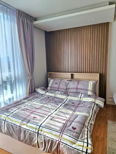 Modern bedroom with stylish decor and large window offering natural light.