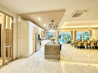 Luxurious open-plan kitchen and dining area with modern design and elegant lighting.