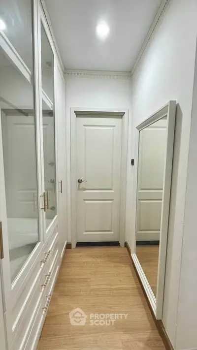Elegant hallway with built-in storage and full-length mirror in modern home.
