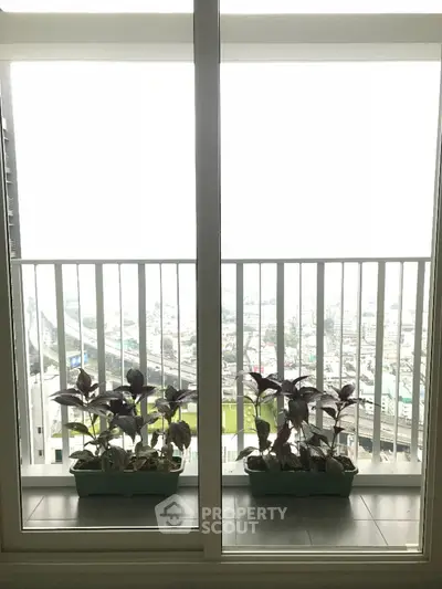 Spacious balcony with city view and potted plants, perfect for relaxation and enjoying urban scenery.