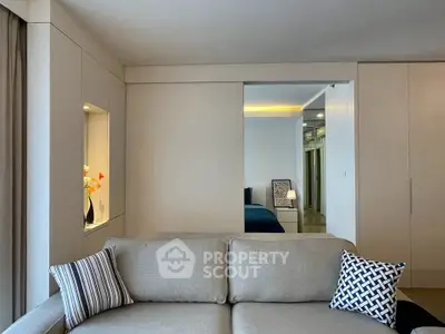 Modern living room with neutral tones and stylish decor, featuring a cozy sofa and elegant design elements.