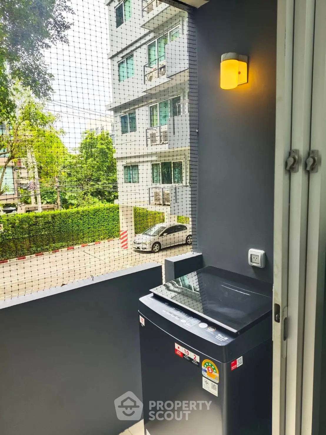 Modern apartment balcony with washing machine and urban view