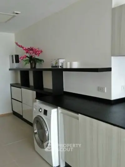 Modern kitchen with sleek cabinetry and built-in washing machine