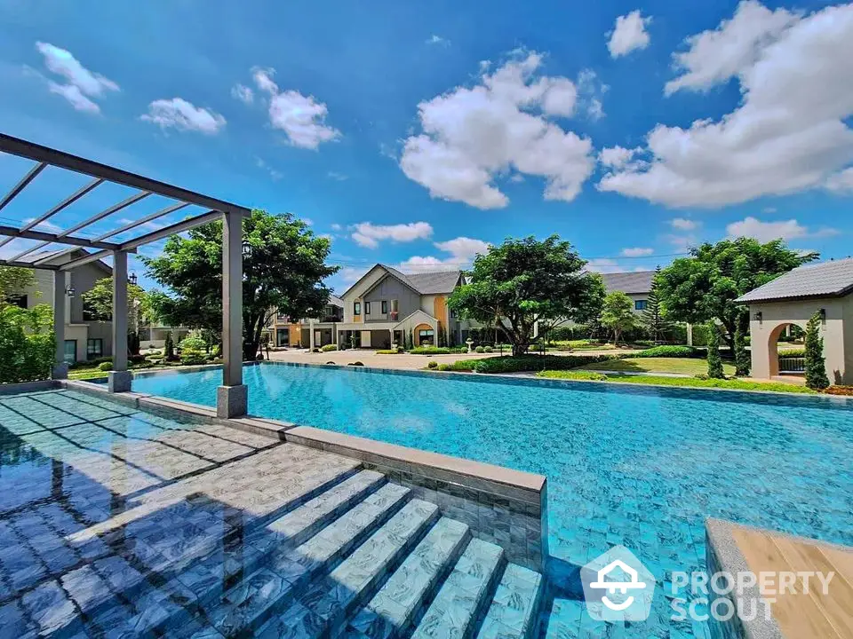 Luxurious residential pool with stunning blue water and elegant architecture under a clear sky.