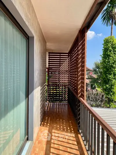 Charming balcony with wooden slats and lush greenery view, perfect for relaxation and enjoying nature.