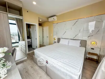 Modern bedroom with city view, featuring stylish decor and ample natural light.