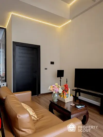 Modern living room with stylish LED ceiling lights, elegant leather sofa, and sleek entertainment unit, creating a cozy and inviting atmosphere.