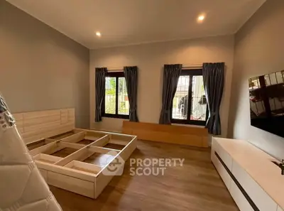 Spacious bedroom with modern wooden flooring and ample natural light