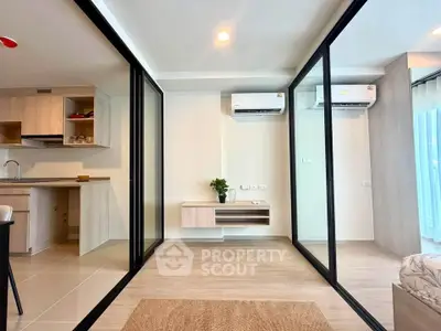 Modern apartment interior with sleek kitchen and spacious living area featuring glass partitions.