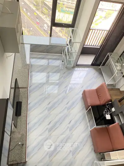 Modern living room with marble flooring and city view from high-rise apartment.
