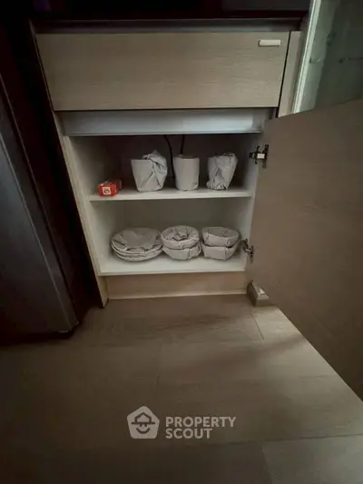 Modern kitchen cabinet with open door revealing organized storage space.