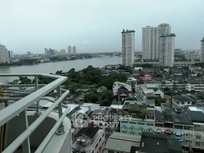 Stunning cityscape view from high-rise balcony overlooking river and skyline.