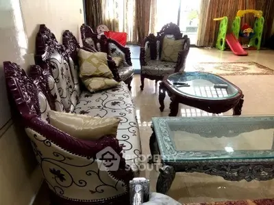 Elegant living room with ornate furniture and children's play area, perfect for family gatherings.