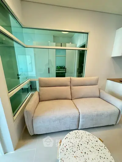 Modern living room with cozy beige sofa and large glass windows