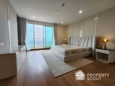 Spacious bedroom with large windows offering ample natural light and a breathtaking view, complemented by elegant furnishings and a cozy ambiance.