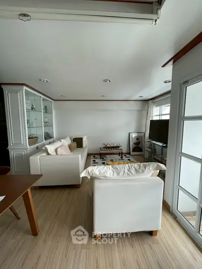 Cozy living room with white sofas and modern decor, perfect for relaxation.