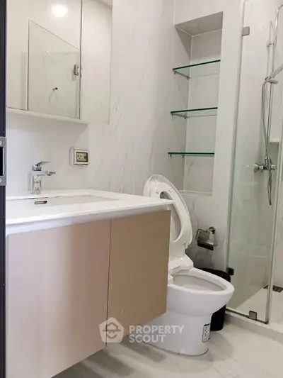 Modern bathroom with sleek design and glass shower enclosure.