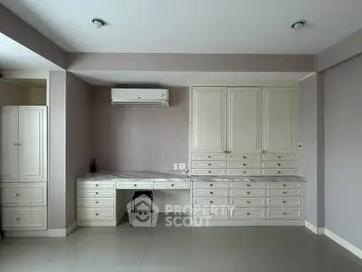 Spacious study room with built-in cabinets and air conditioning, perfect for a home office setup.