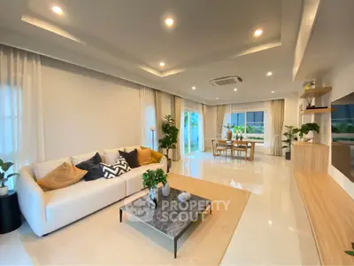 Spacious modern living room with elegant decor and open dining area, perfect for family gatherings.