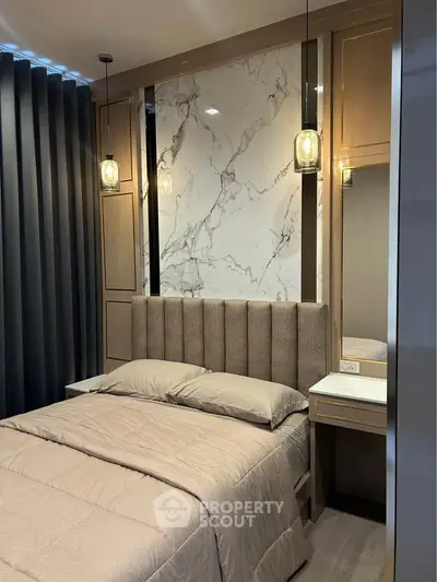 Luxurious bedroom with elegant marble accent wall and modern lighting fixtures.