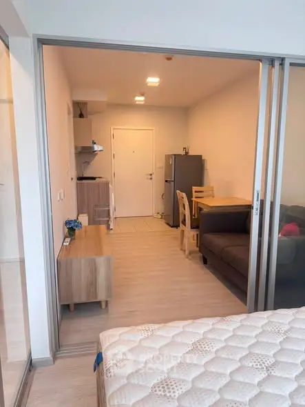 Modern studio apartment with open layout, featuring a cozy living area and compact kitchen.