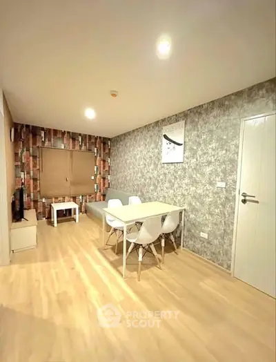 Modern living room with stylish decor and dining area, featuring wooden flooring and contemporary furniture.