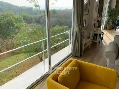 Bright living room with yellow armchair and scenic balcony view